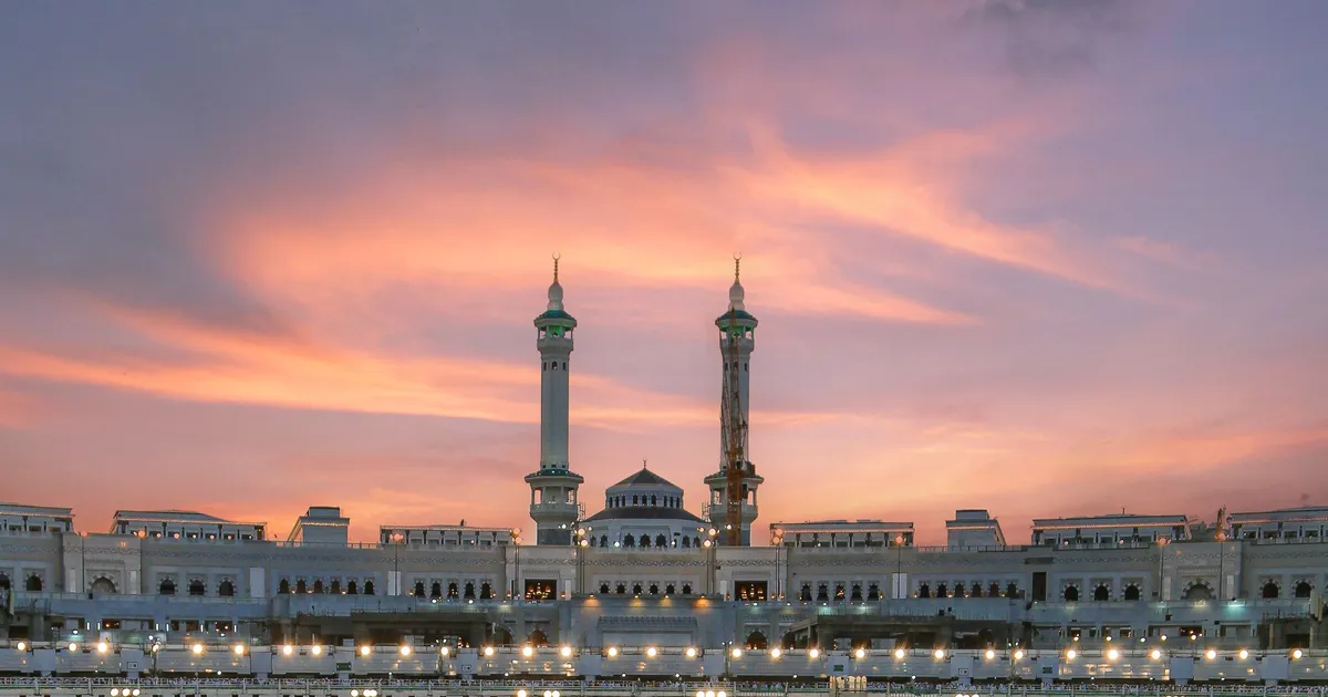 Minarets and the colonnaded facade of the Haram complex in Makkah at sunset